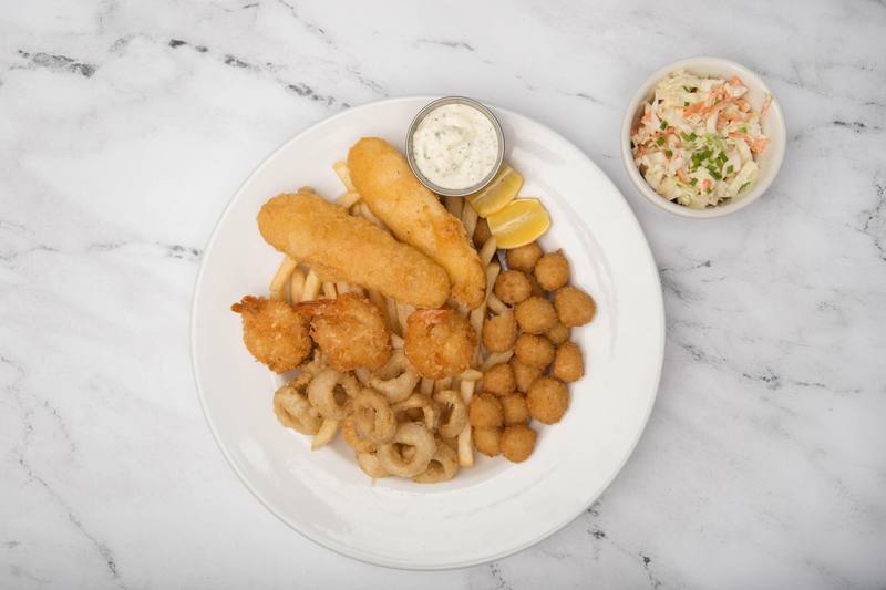 Battered cod, coconut prawns, scallops and calamari rings on fries, with tartar sauce, lemon and a side of coleslaw